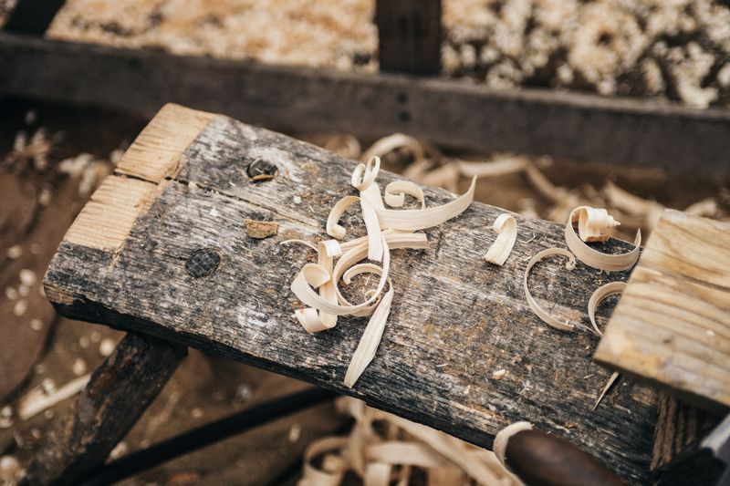 Herramientas de mano de huerta apoyadas sobre un banco de madera en un taller